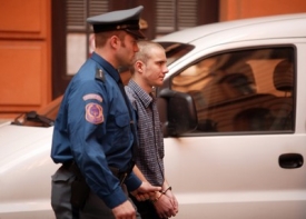 Juraj Lukáš v doprovodu eskorty míří k k soudnímu přelíčení.